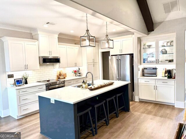 kitchen featuring sink, a breakfast bar area, white cabinetry, a center island with sink, and stainless steel appliances