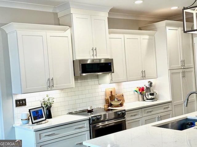 kitchen with decorative light fixtures, tasteful backsplash, white cabinetry, sink, and stainless steel appliances