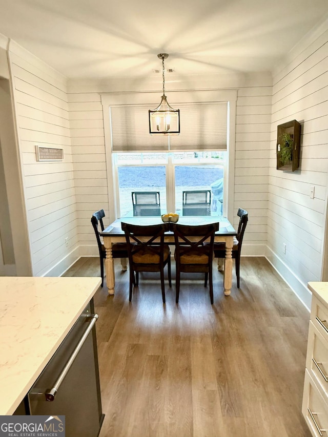 dining space featuring wooden walls and dark hardwood / wood-style floors