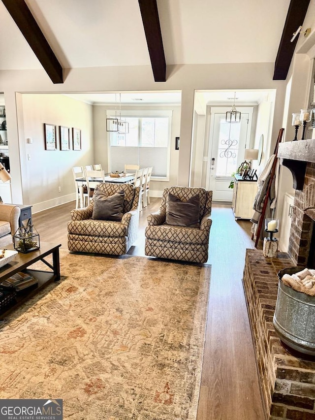 living room with a healthy amount of sunlight, a fireplace, and beam ceiling