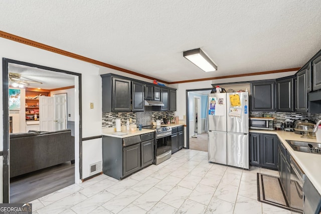 kitchen with ornamental molding, stainless steel appliances, sink, and decorative backsplash