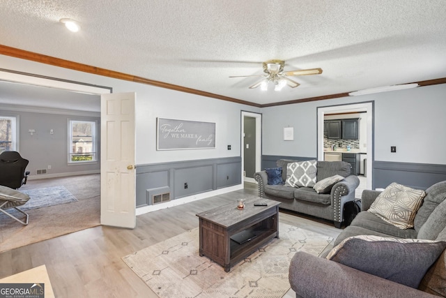 living room featuring ornamental molding and light wood-type flooring