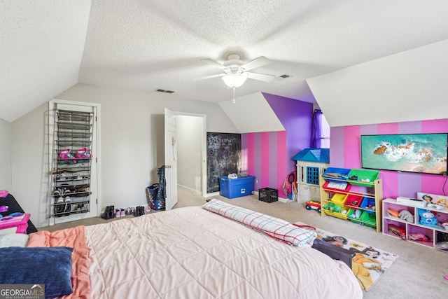 bedroom featuring ceiling fan, light colored carpet, vaulted ceiling, and a textured ceiling