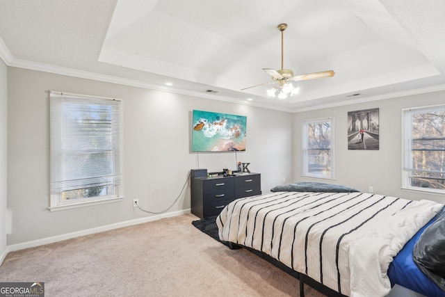 carpeted bedroom with a raised ceiling, crown molding, and ceiling fan