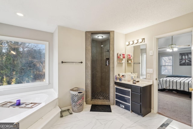 bathroom featuring vanity, ceiling fan, plus walk in shower, and a textured ceiling