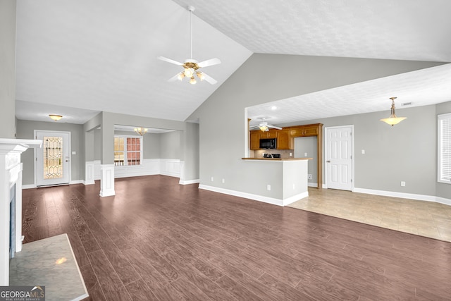 unfurnished living room featuring ceiling fan, dark hardwood / wood-style floors, and high vaulted ceiling