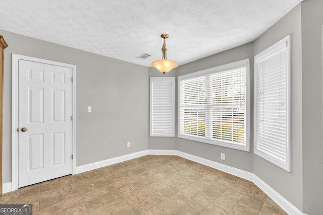 spare room with a textured ceiling