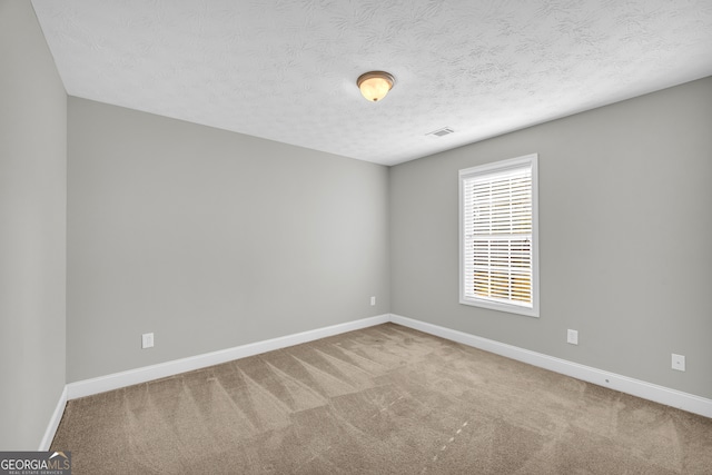 carpeted spare room featuring a textured ceiling