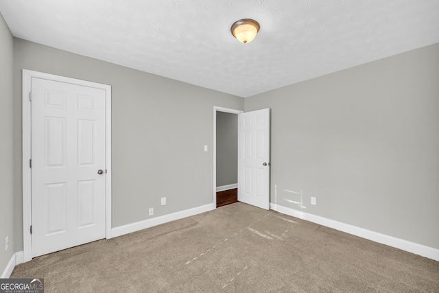 unfurnished bedroom featuring carpet floors and a textured ceiling