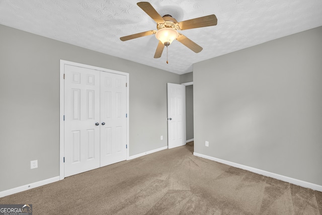 unfurnished bedroom with carpet floors, a closet, and a textured ceiling