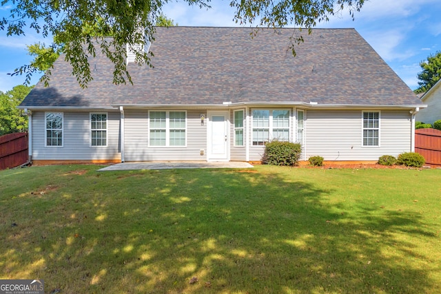 rear view of house featuring a patio and a lawn