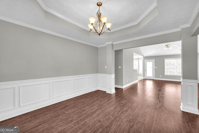 unfurnished room featuring ceiling fan with notable chandelier, dark wood-type flooring, ornamental molding, and a raised ceiling