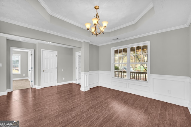 interior space featuring dark wood-type flooring, crown molding, a chandelier, and a raised ceiling