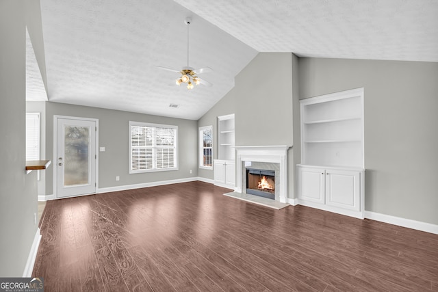 unfurnished living room featuring ceiling fan, hardwood / wood-style floors, a textured ceiling, and a fireplace