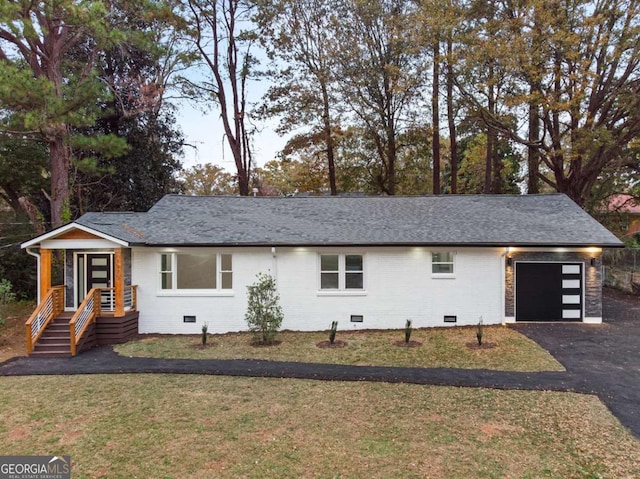 ranch-style home featuring a garage and a front yard