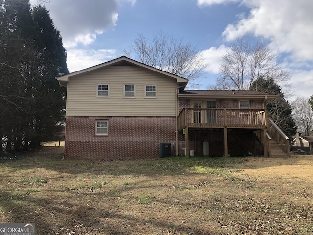 rear view of house with cooling unit, a yard, and a deck