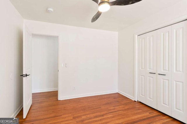 unfurnished bedroom with light hardwood / wood-style floors, a closet, and ceiling fan