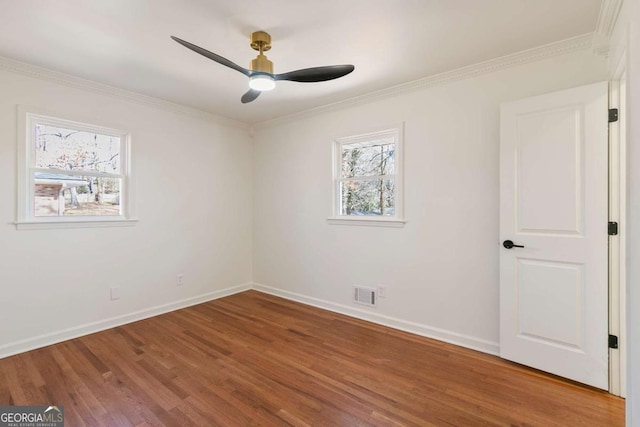 empty room featuring hardwood / wood-style flooring, ornamental molding, and ceiling fan