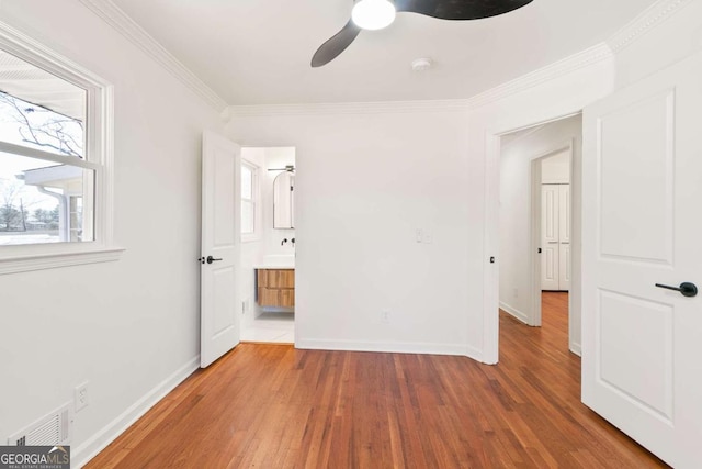 unfurnished bedroom with crown molding, ceiling fan, connected bathroom, and hardwood / wood-style floors