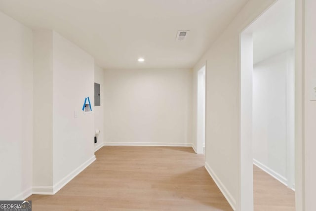 hallway with electric panel and light wood-type flooring