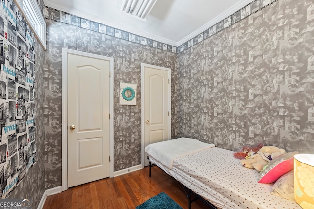 bedroom with ornamental molding and dark hardwood / wood-style flooring