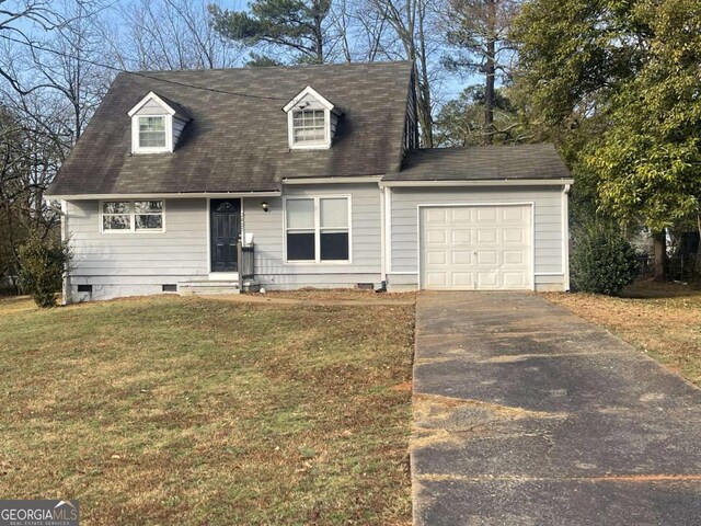 cape cod home featuring a garage and a front lawn