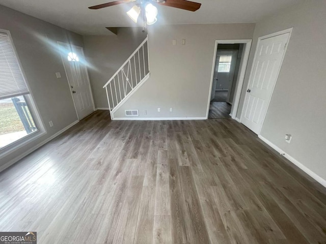 unfurnished living room with wood-type flooring, plenty of natural light, and ceiling fan