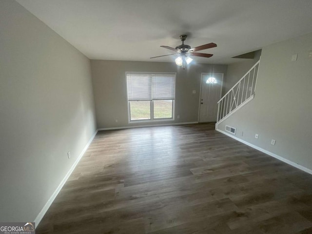 unfurnished living room with dark wood-type flooring and ceiling fan