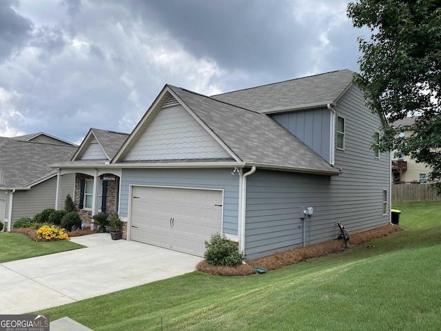 view of front facade with board and batten siding, a front yard, concrete driveway, and a garage