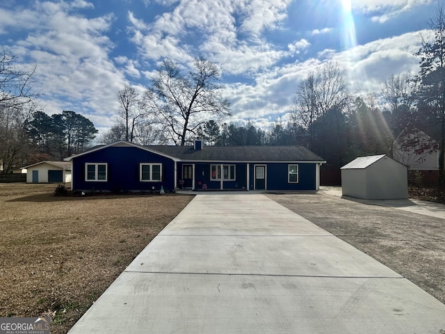 single story home featuring a front lawn and a storage unit