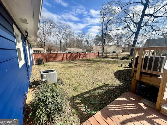 view of yard with central AC and a deck