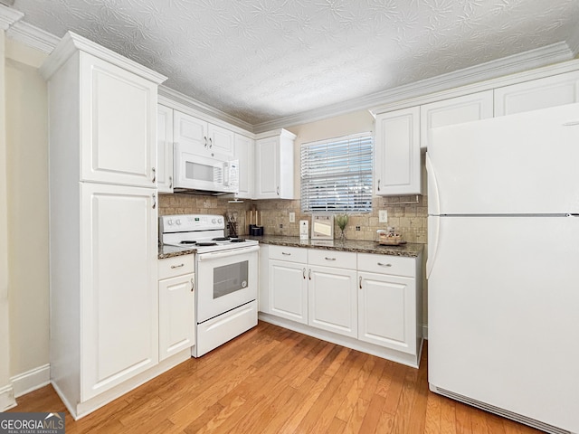 kitchen with white appliances, dark stone countertops, light wood-style flooring, and white cabinets