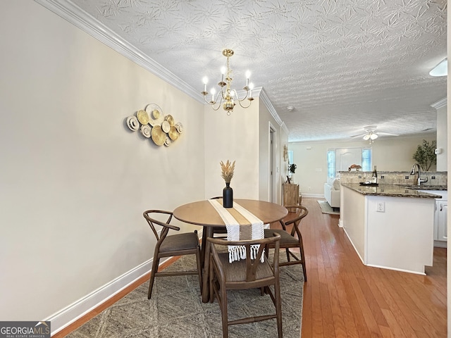 dining space featuring crown molding, baseboards, and wood finished floors