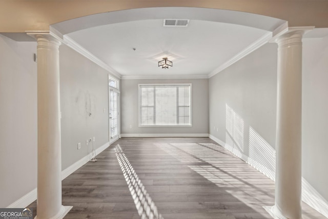 interior space with crown molding, hardwood / wood-style flooring, and ornate columns