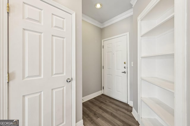 entryway with ornamental molding and dark hardwood / wood-style floors