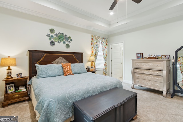 bedroom featuring a raised ceiling, crown molding, light colored carpet, and ceiling fan