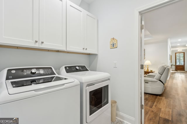 laundry room with separate washer and dryer, dark wood-type flooring, and cabinets