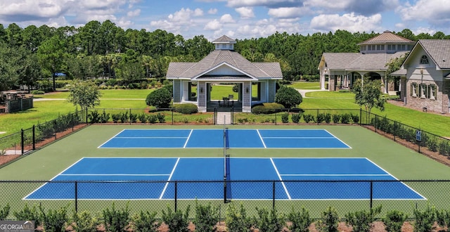 view of tennis court featuring a lawn