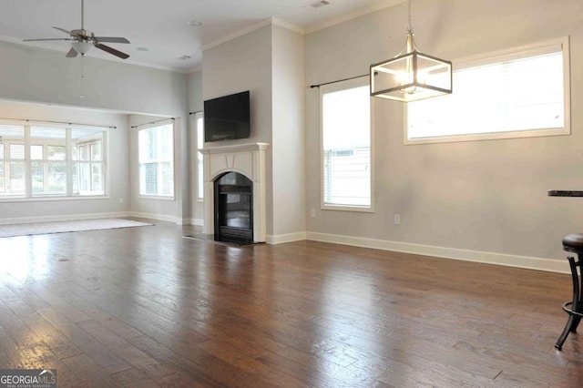 unfurnished living room featuring ornamental molding, dark hardwood / wood-style floors, and ceiling fan with notable chandelier