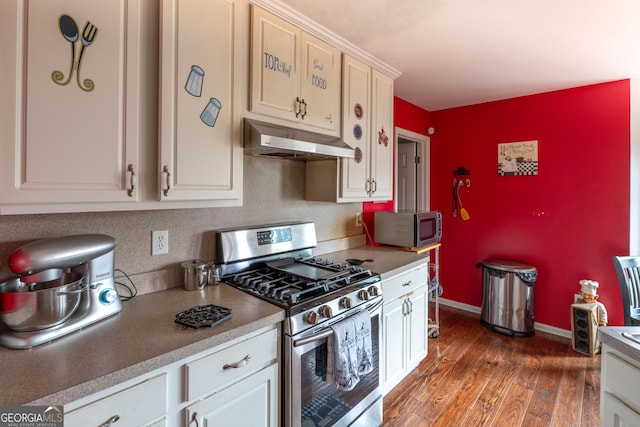 kitchen with stainless steel appliances, white cabinets, and dark hardwood / wood-style flooring