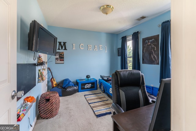 carpeted home office featuring a textured ceiling