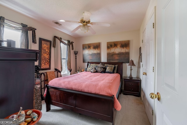 carpeted bedroom featuring ceiling fan and a textured ceiling