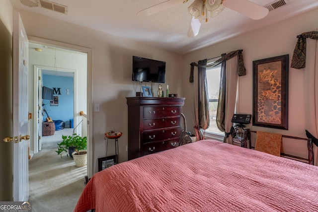 carpeted bedroom with ceiling fan and a textured ceiling