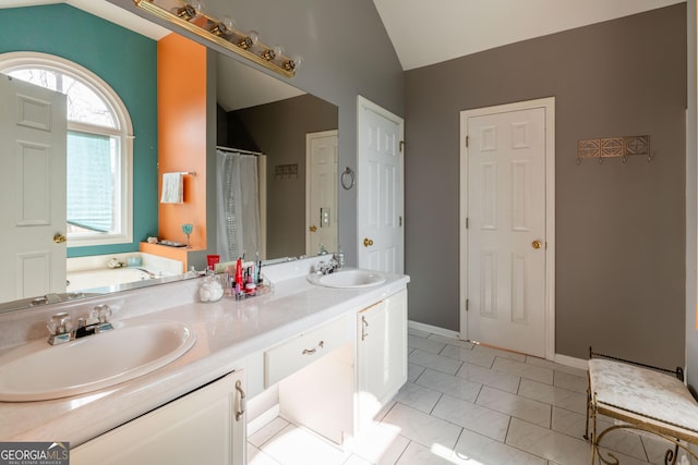 bathroom with lofted ceiling, vanity, and a bath