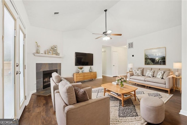 living room with ceiling fan, a fireplace, lofted ceiling, and dark hardwood / wood-style flooring