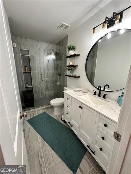 bathroom with vanity, toilet, and walk in shower