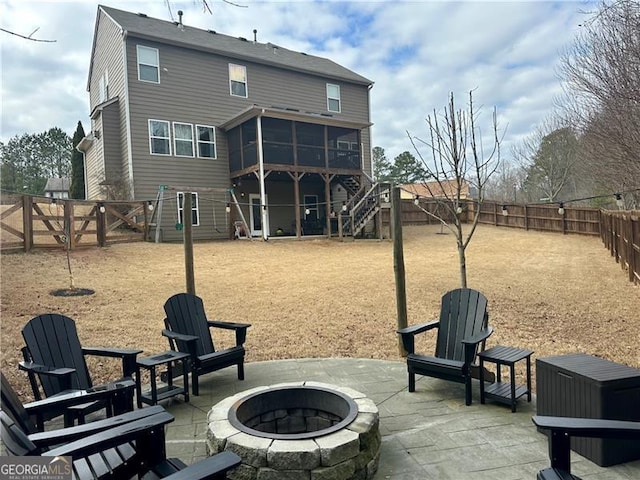 back of property featuring a patio area, a sunroom, and an outdoor fire pit