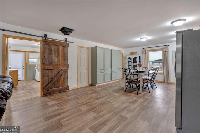 dining room featuring a barn door and light wood-type flooring