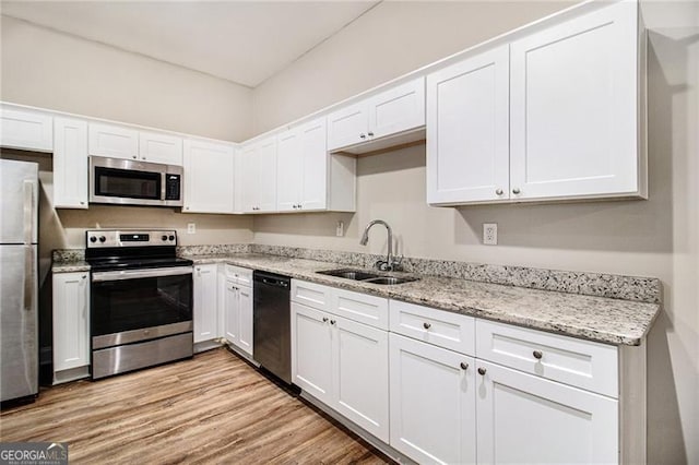 kitchen featuring stainless steel appliances, sink, and white cabinets