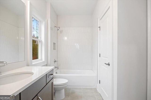 full bathroom with vanity, tiled shower / bath combo, tile patterned floors, and toilet